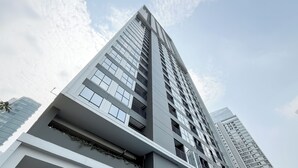 Un moderno edificio de rascacielos con varios pisos, ventanas amplias y balcones.