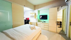 Ein Hotelzimmer mit Bett, Schreibtisch mit Computer, Fernseher und Kleiderschrank.