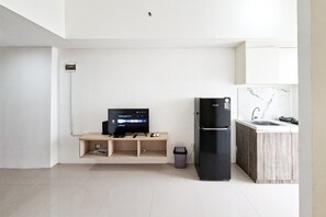 Eine moderne Küche mit integriertem Kühlschrank, einer Holzregaleinheit und einer kleinen Mülltonne.