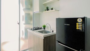 Una cucina moderna con un frigorifero nero, una cucina a gas, un lavello e una porta scorrevole in vetro.