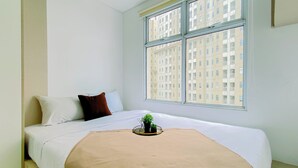 Una camera da letto con un letto, una finestra e vista sugli edifici.