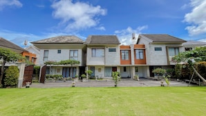 A row of modern houses with a well-maintained lawn and garden in front. - Serene Designed And Homey Studio At Villa Casa De Uli (Nusa Dua)