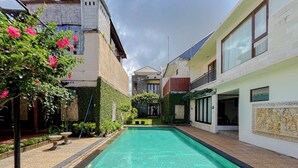 A rectangular swimming pool with a clear blue water surface, surrounded by a tiled deck. - Serene Designed And Homey Studio At Villa Casa De Uli (Nusa Dua)