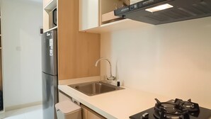 A modern kitchen with a stainless steel refrigerator, a sink, and a gas stove. - 2Br Apartment At Tokyo Riverside Pik 2 Near Nice (Teluknaga)