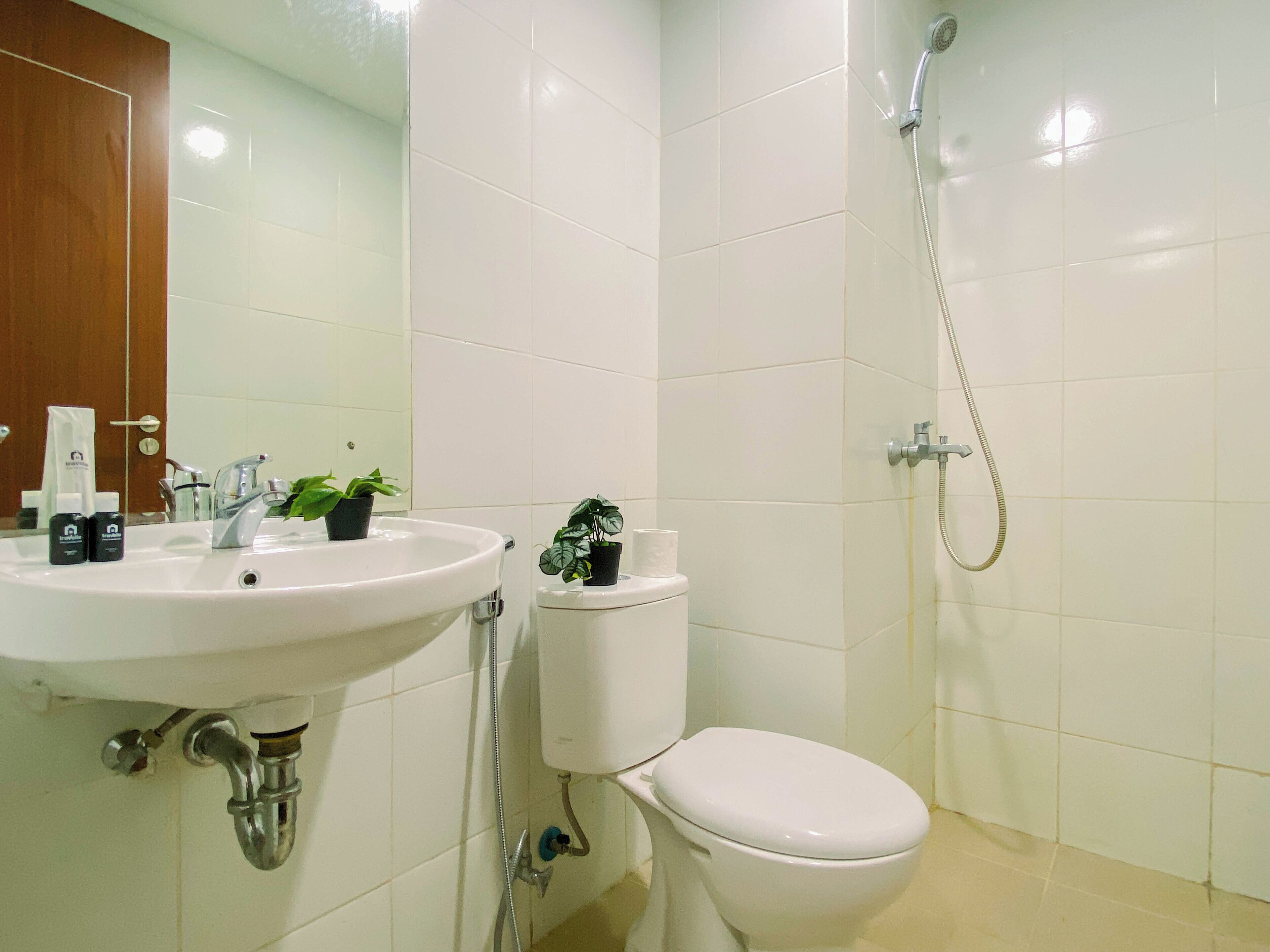 A bathroom with a white sink, toilet, and shower.
