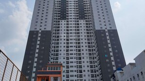 Un edificio residencial alto con varios pisos, balcones y un núcleo central.