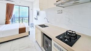 Una cocina moderna con estufa integrada, un lavamanos y una ventana con vistas a un paisaje urbano.