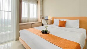 A hotel room with a large bed, a desk with a computer, and a window with sheer curtains. - Modern Studio Apartment Near Sicc At Royal Sentul Park (Bogor)