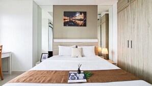 A neatly arranged hotel room with a large bed, a bedside table with a lamp, a framed picture on the wall, and a wardrobe. - Enjoy Living Studio For 2 Pax At Springwood Residence Tangerang (Tangerang)