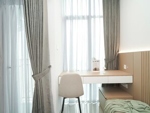 Un dormitorio moderno con una cama, un escritorio y una silla.