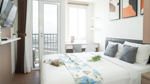 A modern bedroom with a bed, a desk, and a balcony. - Tranquil Studio For 2 Pax At Tokyo Riverside Pik 2 Apartment (Teluknaga)