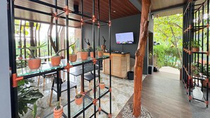 Um interior moderno com divisória de vidro, teto de madeira e plantas em vasos.