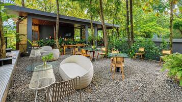 A modern outdoor patio with seating, tables, and potted plants.