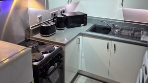Eine moderne Küche mit Gasherd, Mikrowelle und Kaffeemaschine.