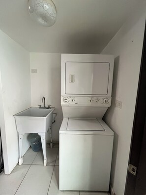 A compact kitchen with a sink, a washing machine, and a small countertop. - Tremendous 4-bedroom house with AC in charming Tijuana (Tijuana)