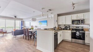 A modern kitchen with white cabinetry, stainless steel appliances, and a central island. -  Sunrise lake view from the balcony. 3-bedroom condo near Disney/universal. (Orlando)