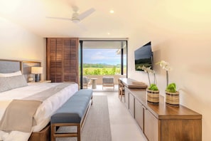 A modern bedroom with a large bed, a desk, and a balcony with a view of the countryside. - Condo Tukipa–Lake & Golf Views in Punta Mita (Punta Mita)