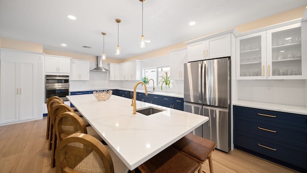 A modern kitchen with white cabinets, stainless steel appliances, and a central island with seating. - 3229 Managed by Brampton Park (Pompano Beach)