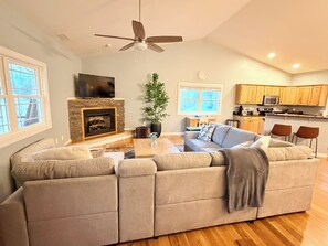 Ein Wohnzimmer mit Kamin, einer Couch, einem Couchtisch und einem Fernseher.