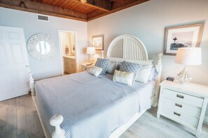 Ein Schlafzimmer mit Bett, Nachttischen, einem Spiegel und einer Wanduhr.