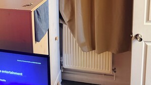 Une pièce avec un téléviseur affichant l’écran de connexion à Netflix, un radiateur et une porte.