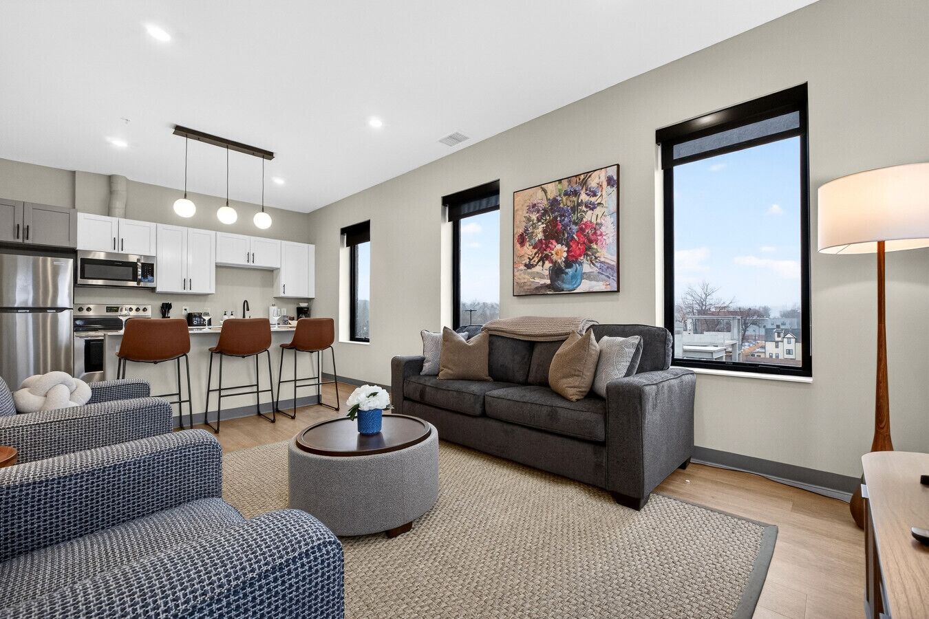 A modern apartment with a kitchen, dining area, and living room.