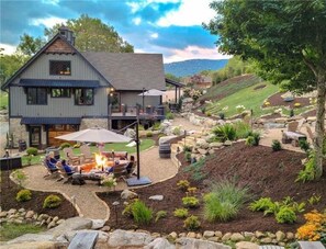 A two-story house with a patio area featuring a fire pit and outdoor seating. - Black Diamond at Eagles Nest: Views, Hot Tub, Pet Friendly! (Banner Elk)
