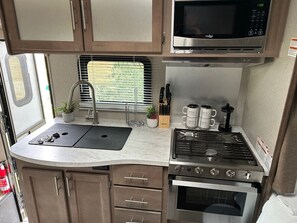Fridge, stovetop, cookware/dishes/utensils, dining tables - The Cozy Coach Glamper (Stettler)