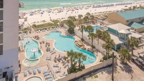 Um resort com várias piscinas, uma praia e vista para o oceano.