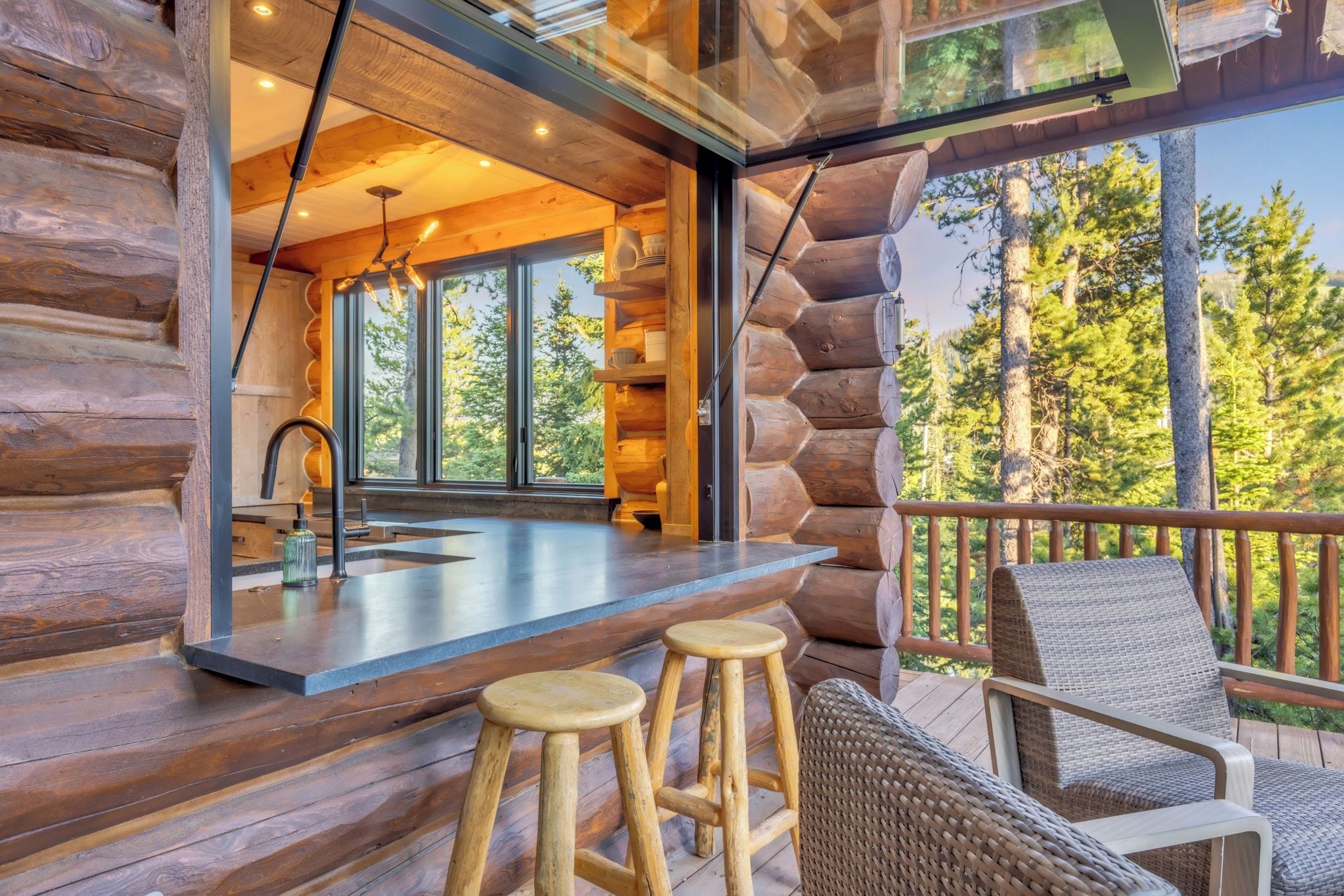 A log cabin with a bar area, wooden stools, and wicker chairs.
