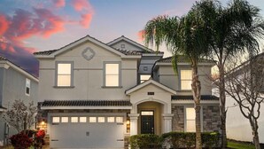 A two-story house with a garage, a stone facade, and a well-maintained lawn. - Epic 8BR Escape: Themed Rooms, Home Cinema & Pool/Spa (Davenport)