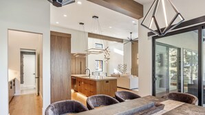Une cuisine moderne avec des meubles en bois, un îlot central et des luminaires suspendus.