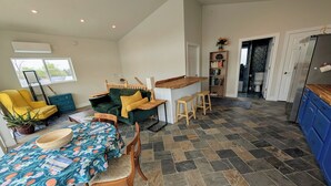 A modern kitchen with a dining area, a sofa, and a small bar area. - Airy 1-bedroom townhome in charming Aurora with AC (Aurora)
