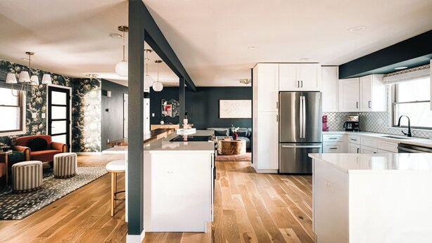 Eine moderne Küche mit weißen Schränken, einem Edelstahlkühlschrank und einer Holztheke.