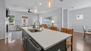 A modern kitchen with a large island, built-in appliances, and pendant lighting. - The Lazy Yorkie | Family Beach Getaway | Sleeps 10 | Great Rates (Inlet Beach)