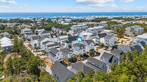 A residential area with white houses, a clear blue sky, and a view of the ocean. - The Lazy Yorkie | Family Beach Getaway | Sleeps 10 | Great Rates (Inlet Beach)