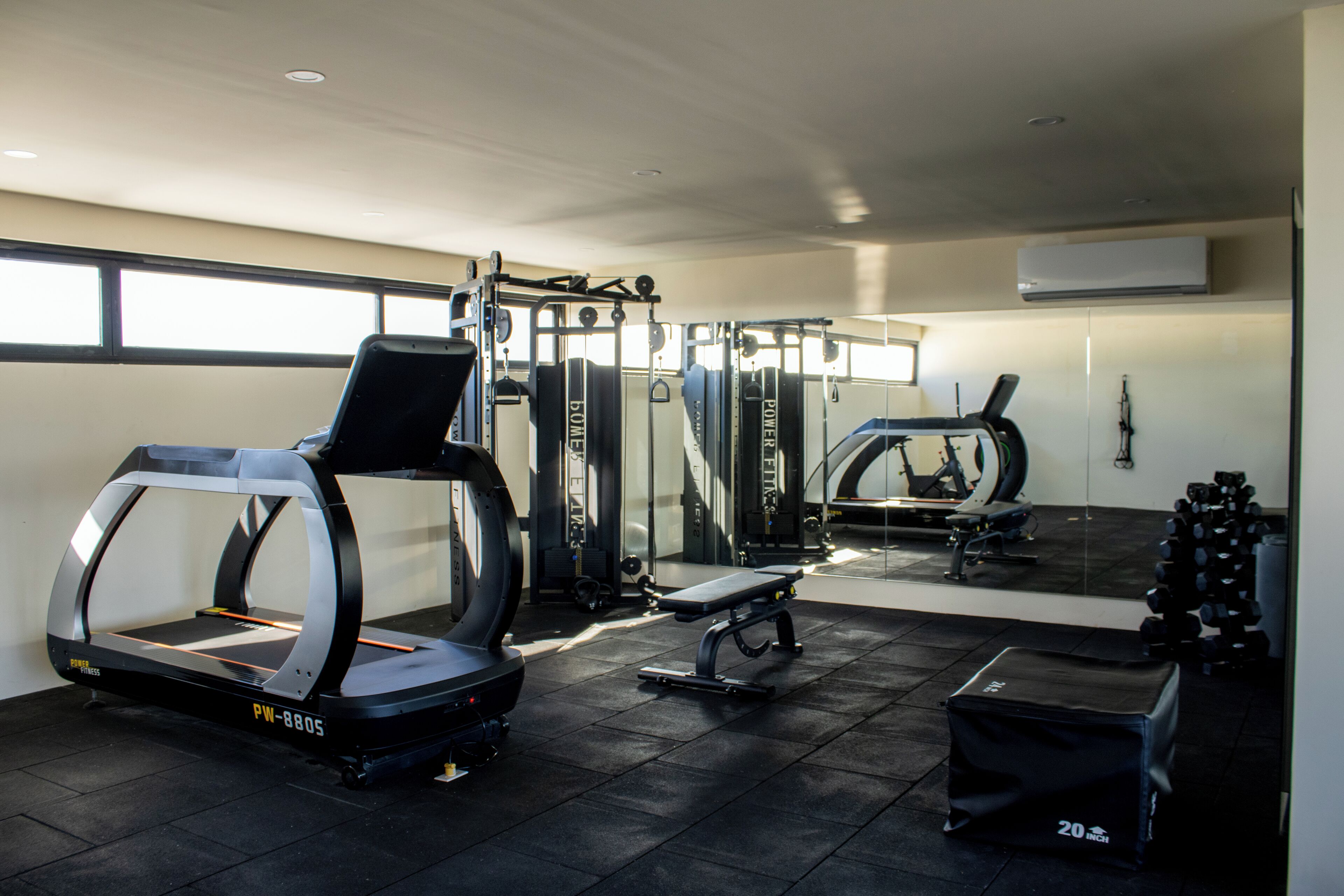 A gym with treadmills, weight machines, and free weights.
