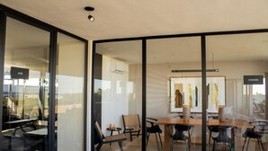 A modern interior with a glass wall, a wooden table, and black chairs. - Paravian 704 2BR Condo Playa del Carmen (Playa del Carmen)