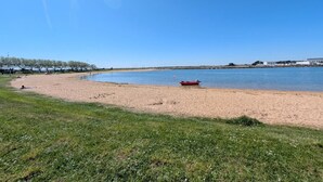 A beach with a sandy shore, a small boat, and a clear blue sky. - Les Sternes - ETEL - Gîte (ETEL)