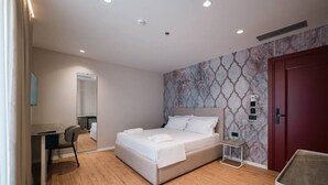 Habitació d'hotel moderna amb un llit, una taula de treball i una cadira.
