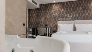 Ein modernes Hotelzimmer mit einem großen Bett, einem Schreibtisch und einem Stuhl.