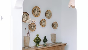 Una stanza con un tavolo consolle in legno, piatti decorativi e un pavimento a motivi.