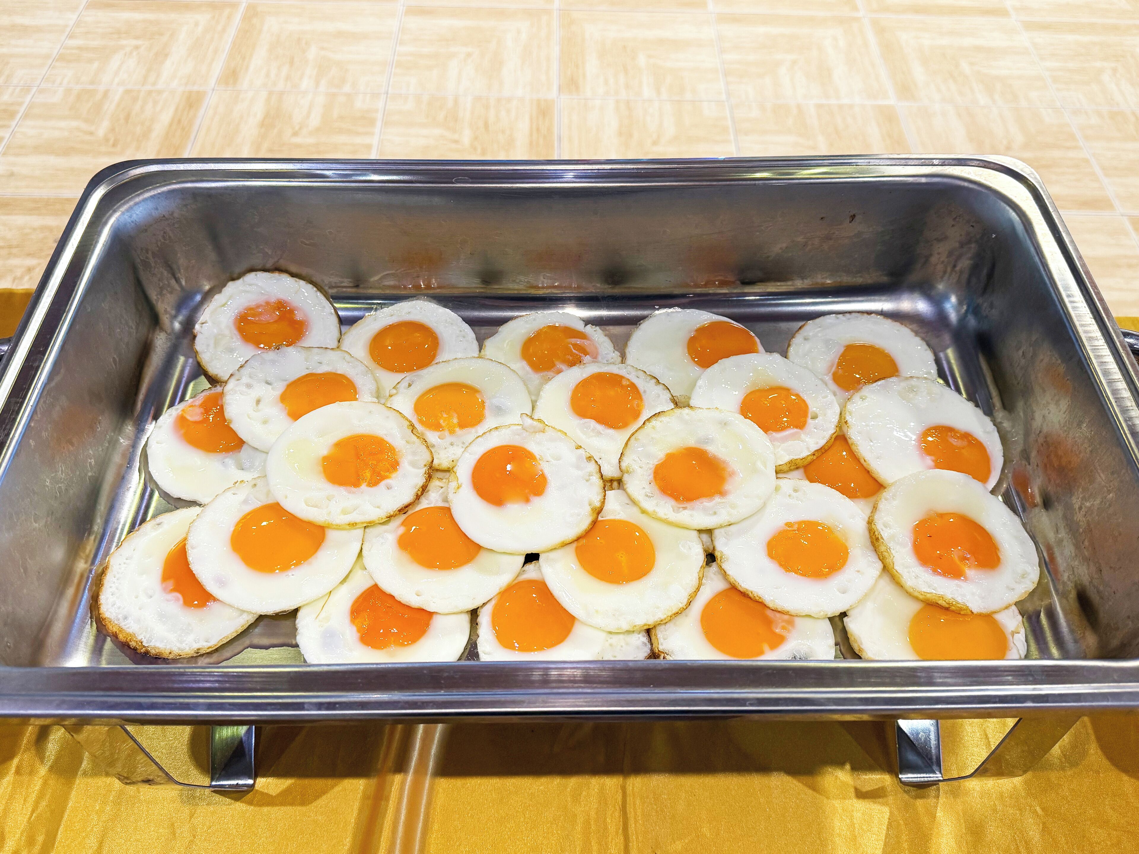 A metal tray filled with fried eggs.