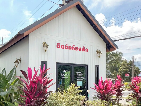 A building with a white exterior and a sign in a non-English script. - Khanom Paradise Resort (Khanom)