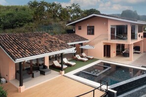 A modern two-story house with a swimming pool, outdoor seating, and a covered patio. - 5BR/6BA Luxury Jungle Villa w/ Breathtaking Views! (Playa Hermosa)