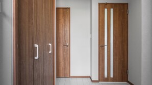 A hallway with wooden doors and white walls.