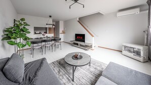 A modern living room with a sofa, coffee table, and a TV displaying 'NETFLIX'.