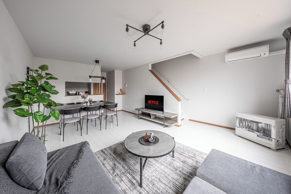 A modern living room with a sofa, coffee table, and a TV displaying 'NETFLIX'. - HILLS NISEKO D (Niseko)