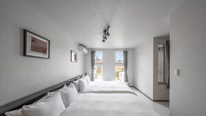 A hotel room with a large bed, a headboard, and a ceiling light fixture.