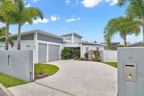 Un quartier résidentiel moderne doté d’une entrée sécurisée, d’une allée et d’une maison avec un garage.